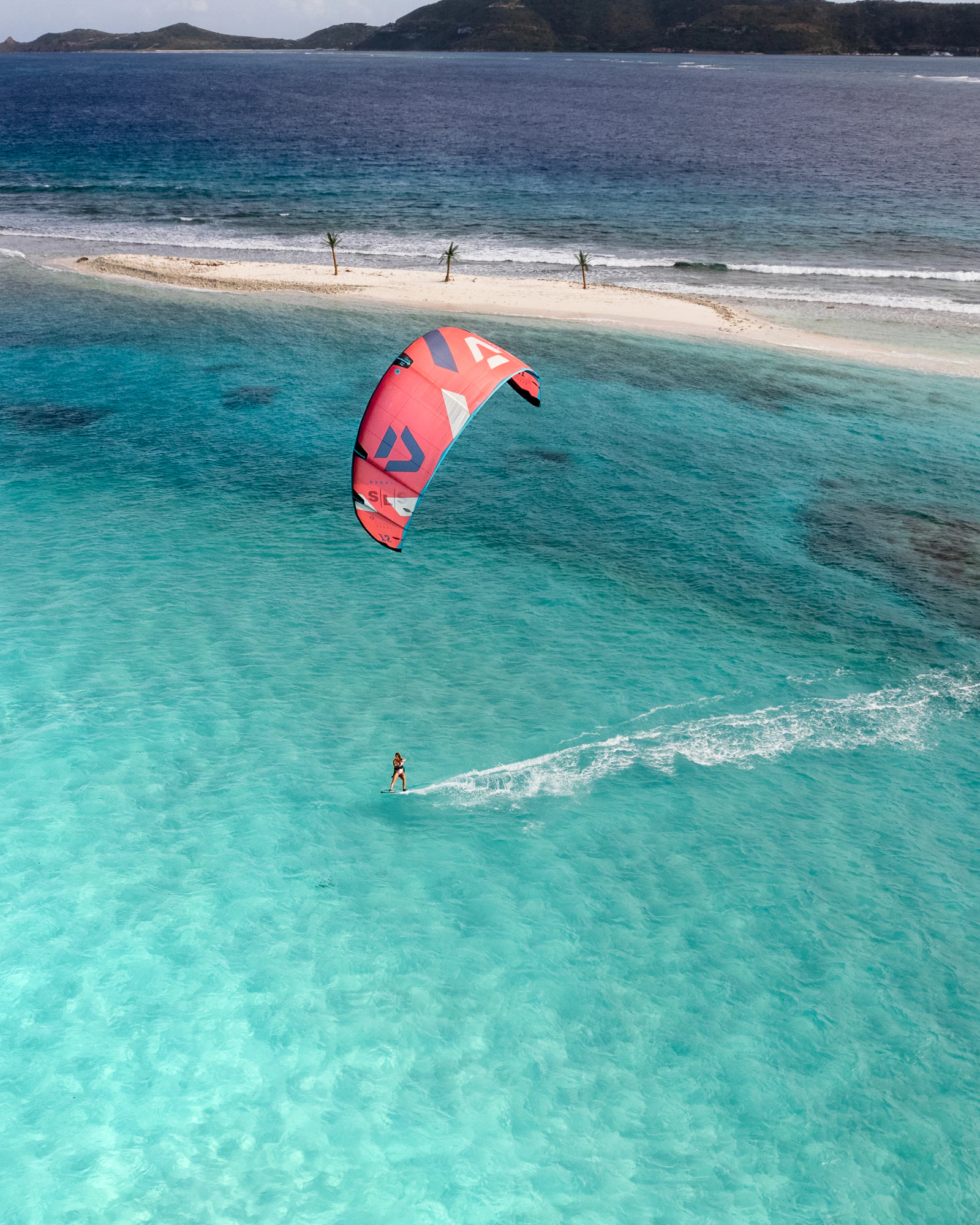 Kitesurf visto desde el aire sobre aguas turquesas